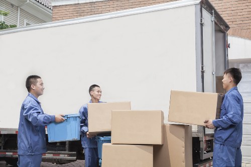 Movers preparing a home relocation in Coneyhall with packed boxes and furniture