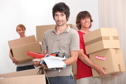 Professional movers carrying household furniture during a Coneyhall home move